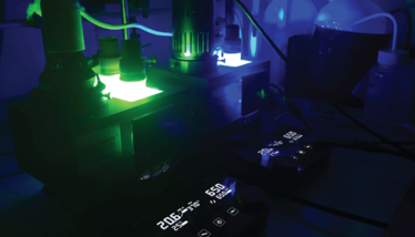 A shot of the lab equipment, from which green and blue glows emit.