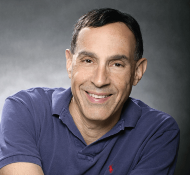 A head and shoulders portrait photograph of Ken Gruber. He is smiling.