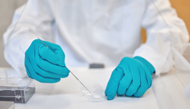 Close up of the gloved hands of a lab worker using Nanoform's product